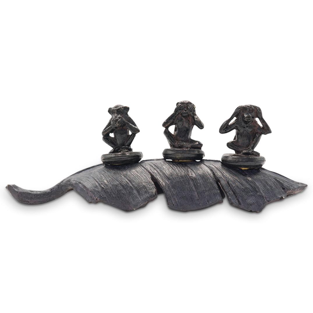 "Speak No Evil" Monkey Wine Stoppers: DESCRIPTION: A collection of three "Speak no, Hear no, See no evil" wine stoppers composed of painted composite with monkey motif designs, rests in a leaf formed stand. CIRCA: 21st Cent. ORIGIN: USA D