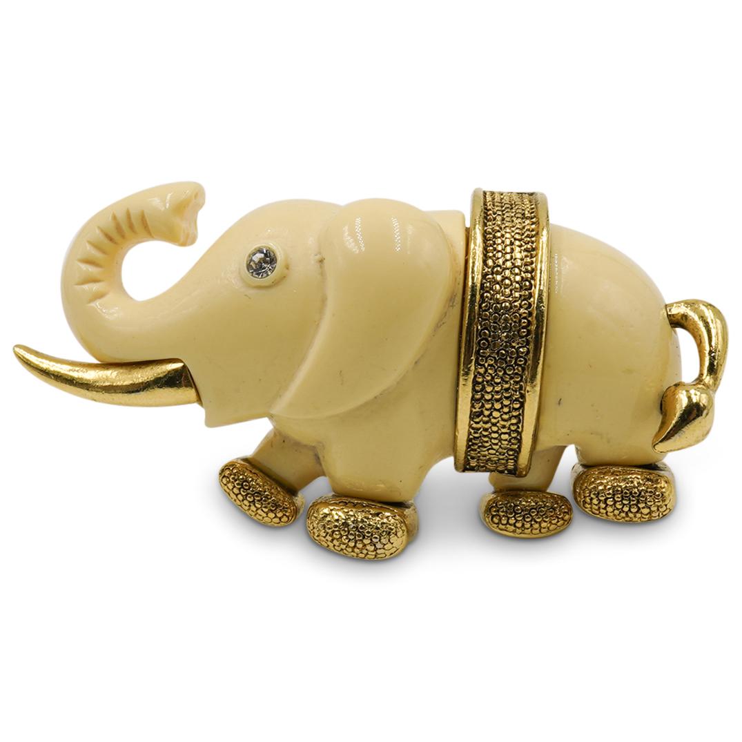 Gold Tone Elephant Brooch: DESCRIPTION: A gold toned elephant brooch composed of beige colored enamel and crystal set eyes. CIRCA: 20th Cent. ORIGIN: Unknown DIMENSIONS: W: 1.25" x L: 2.25" CONDITION: Great condition. See lot d