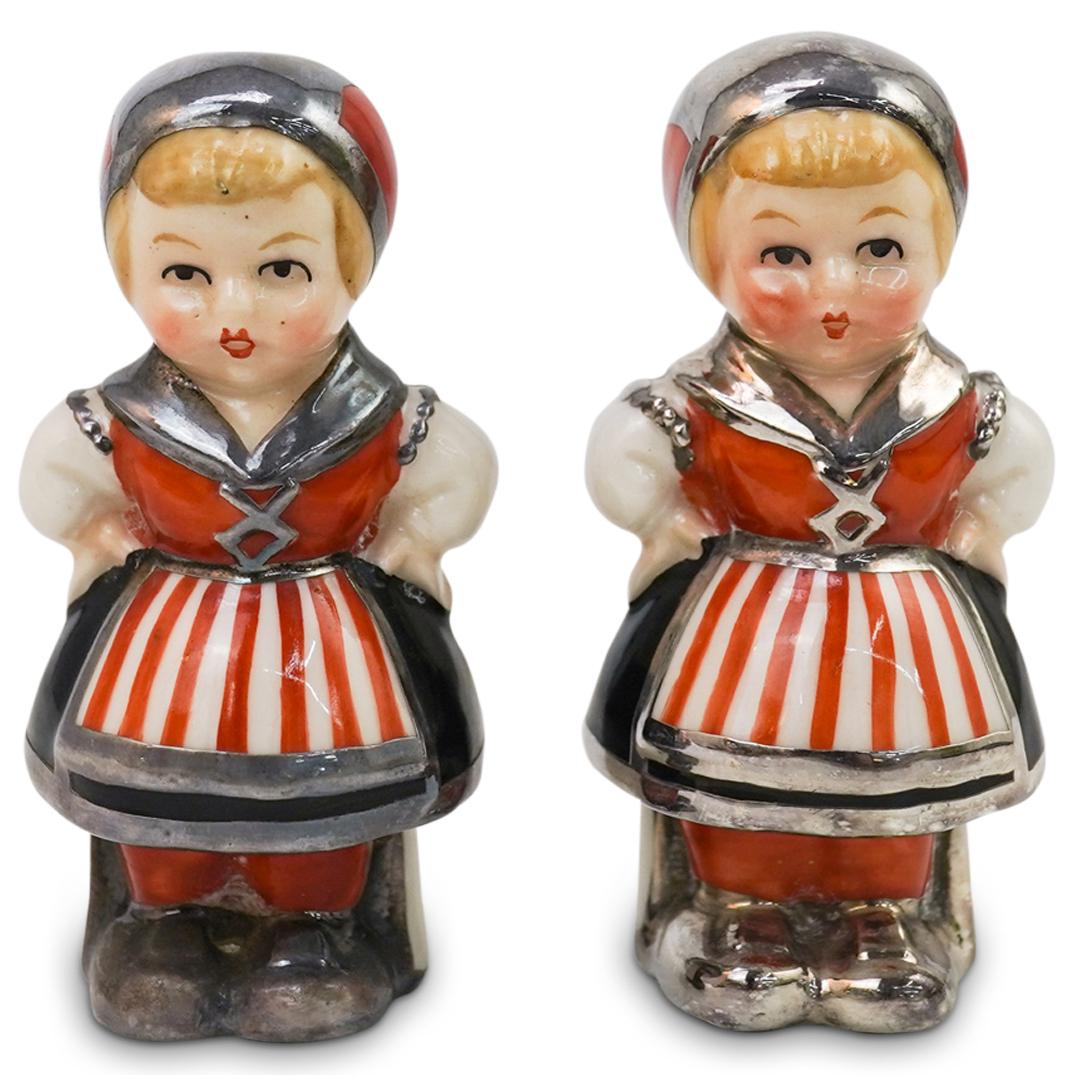 Goebel Figural Salt & Pepper Shakers: DESCRIPTION: Goebel Porcelain Figural Salt & Pepper Shakers. Modelled as a boy and girl wearing traditional rural garments. Finished with a silver overlay design. CIRCA: 19th/20th ORIGIN: Germany DIME