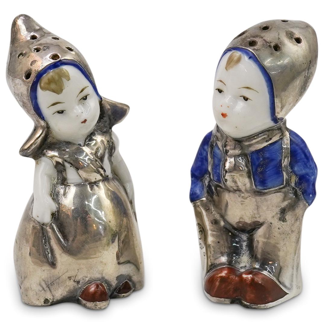 Goebel Figural Salt & Pepper Shakers: DESCRIPTION: Goebel Porcelain Figural Salt & Pepper Shakers. Modelled as a boy and girl wearing traditional rural garments. Finished with a silver overlay design. CIRCA: 19th/20th ORIGIN: Germany DIME