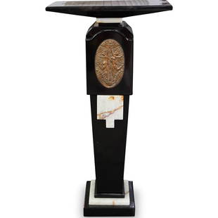 After Demetre Chiparus (Romanian 1886-1947) Pedestal: DESCRIPTION: An Art Deco style onyx pedestal after Demetre Chiparus. Features overall black onyx with white onyx accents. Finished with a bronze plaque along the center of the stem with embossed