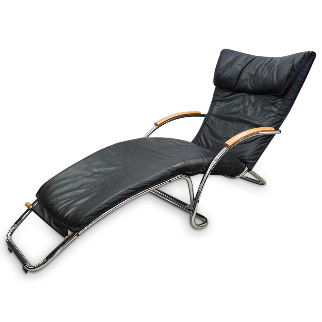 Mid Century Leather Lounge/Rocking Chair: DESCRIPTION: A Mid century black leather lounge chair with chrome foundation and light wood accents.Converts into rocking chair. CIRCA: 20th Cent. ORIGIN: Unknown DIMENSIONS: H: 34" x W: 26" x L: 66" 
