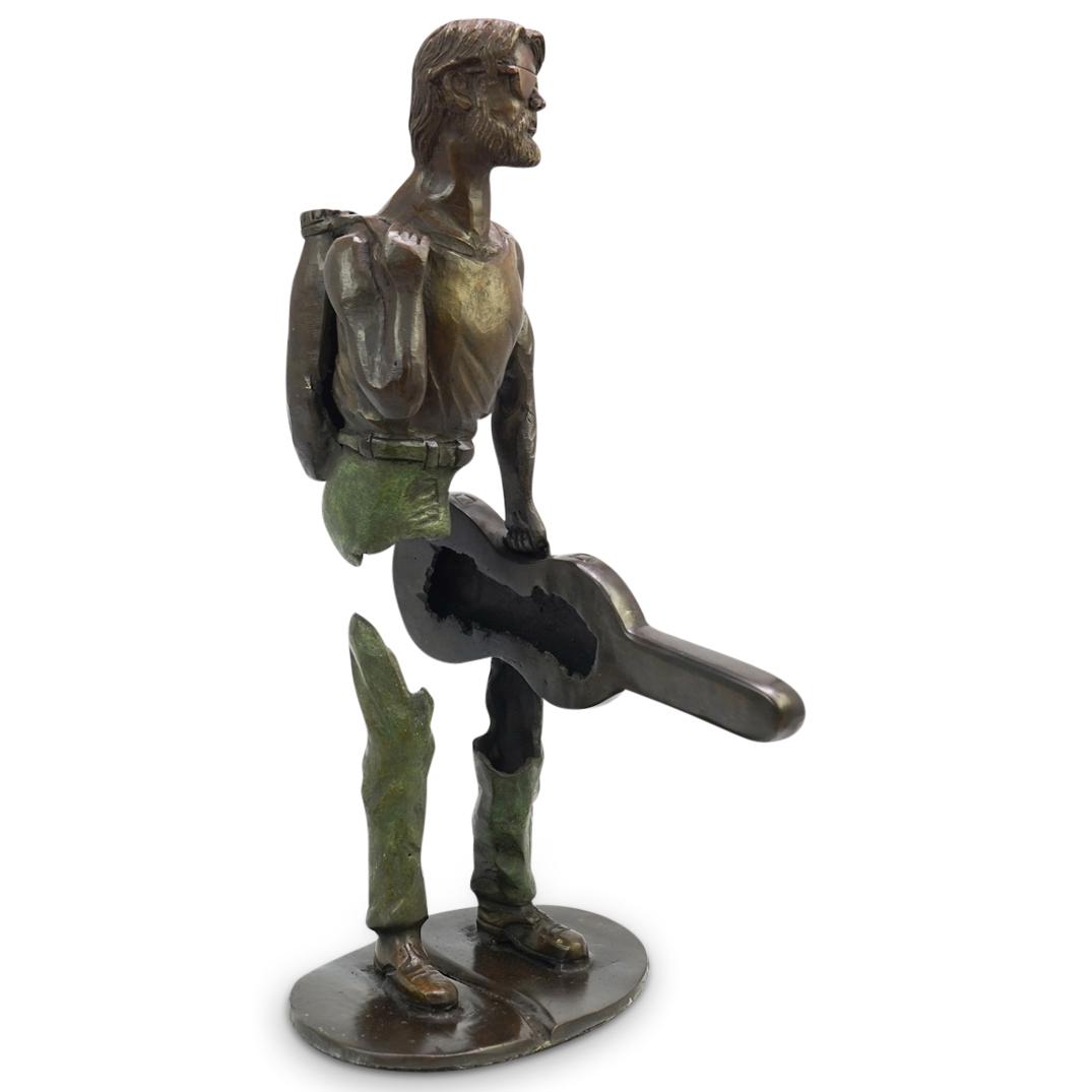 After Bruno Catalano Bronze Sculpture: DESCRIPTION: After Bruno Catalano figural bronze statue. Features a two part bronze with polychrome patina depicting a formal suited man holding a musical instrument. CIRCA: 20th Cent. ORIGIN: Unknown