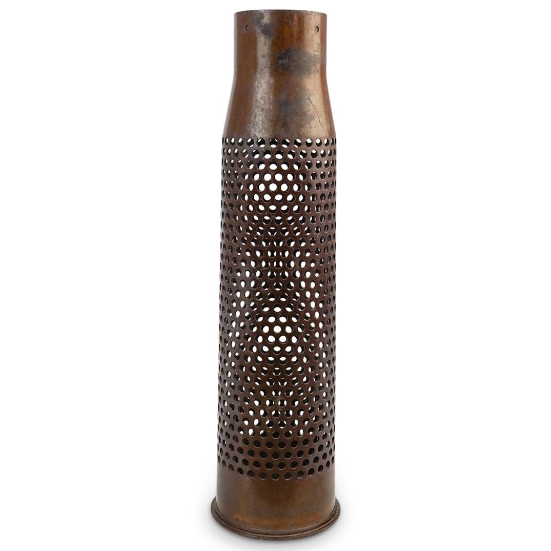 Metal Ammunition Artillery Shell: DESCRIPTION: Metal ammunition artillery steel case shell. This is a 75mm casing from an artillery shell. The steel case, painted dark brown and perforated with 1/4" holes to vent the propellant gases.