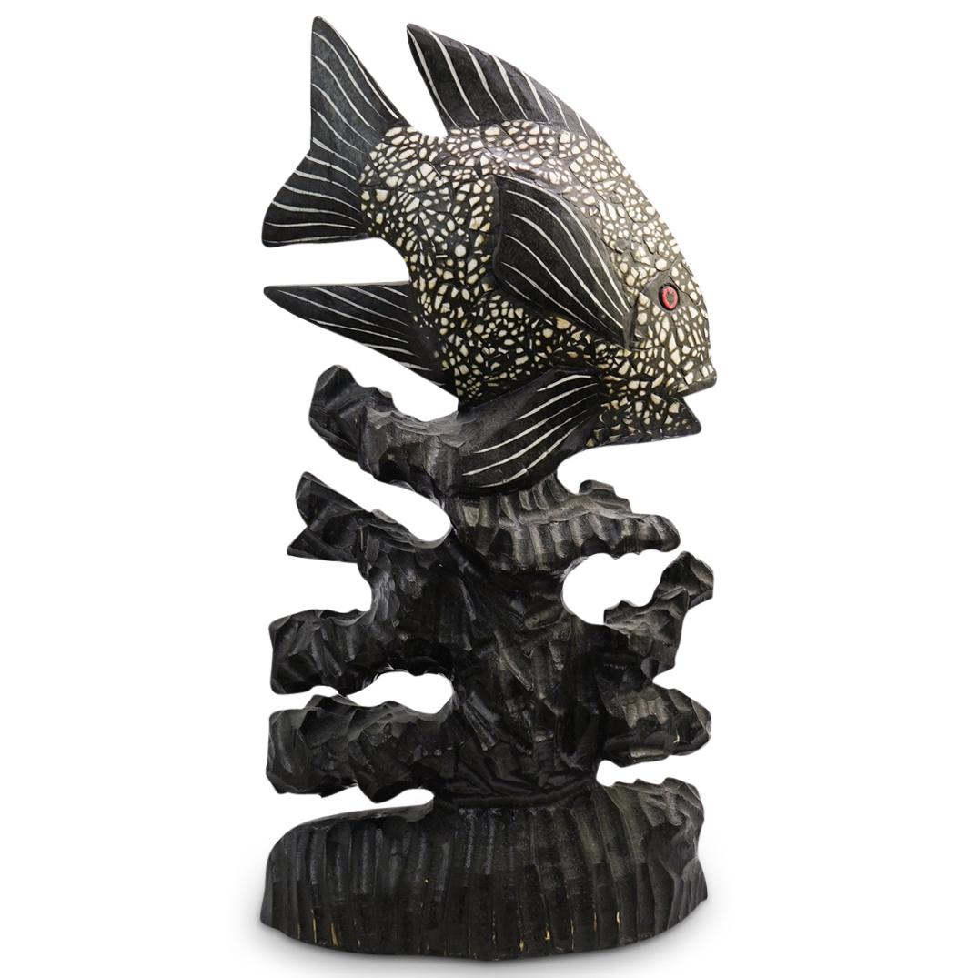 Carved Wood Fish Sculpture: DESCRIPTION: Carved Wood Fish Statue made from one piece of wood in a realistic design with red eyes and white inlaid details.CIRCA: 20Th CenturyORIGIN: IndonesiaDIMENSIONS: H: 20 " W: 10" D:3 1/2 "CO