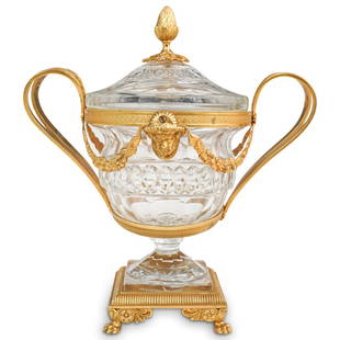 Baccarat Style Gilt Bronze and Crystal Urn: DESCRIPTION: A Baccarat style urn composed of a cut crystal center body, affixed to a gilt bronze frame with two flanking handles, garnished along the body with ornate floral wreaths and satyr