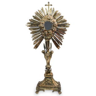 Antique Religious Silver Monstrance: DESCRIPTION: An Antique Religious Monstrance or relic holder with a center glass container, the body composed of silver with a gilt varnish. Features figural angel visages throughout the top and