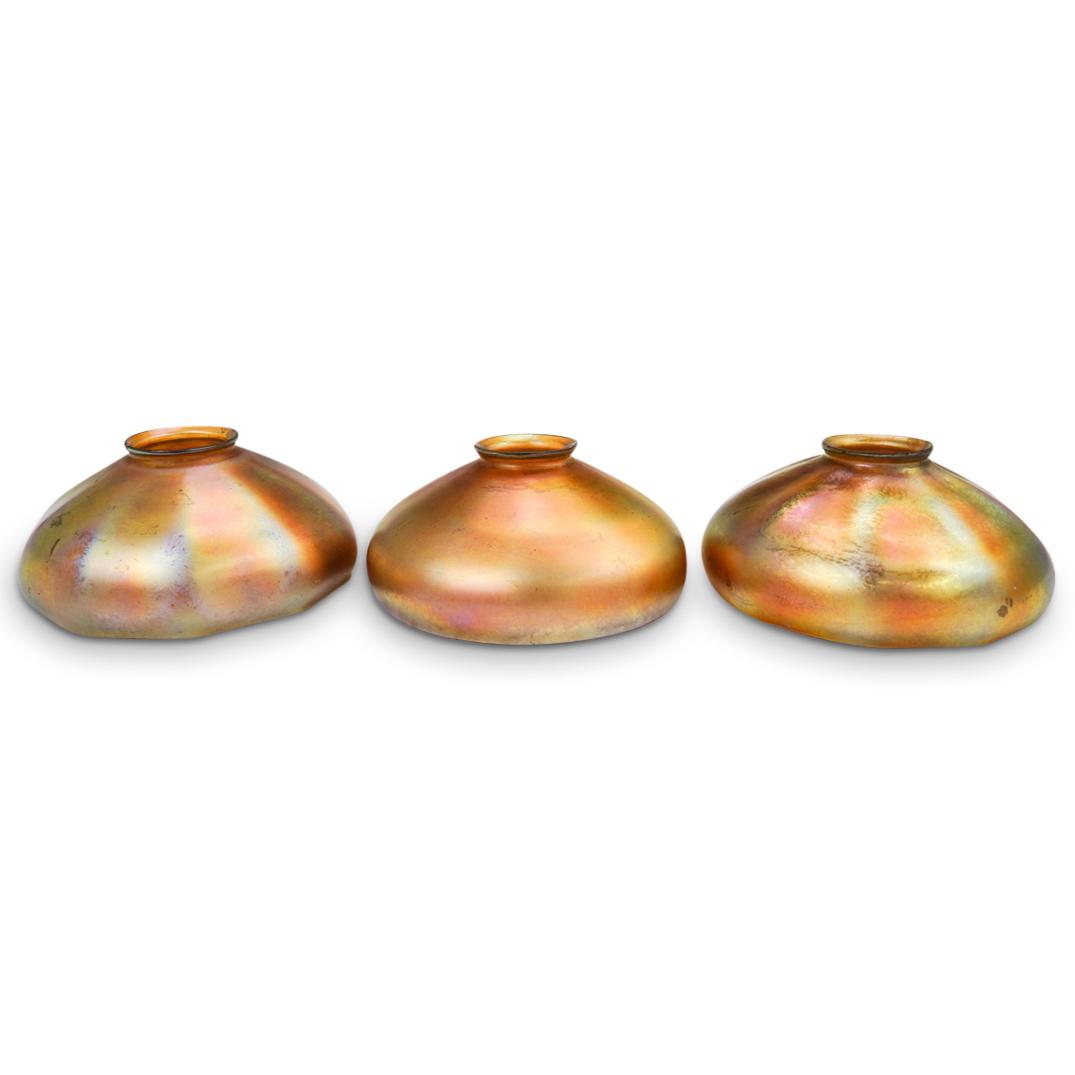 (3 Pc) Steuben Iridescent Glass Shades: DESCRIPTION: (3Pc) A three piece grouping of "Steuben" glass shades with iridescent gold hues. Marked "Stuben" along rim. CIRCA: ORIGIN: USA DIMENSIONS: H: 3.5" x D: 7" CONDITION: Great condition, fle