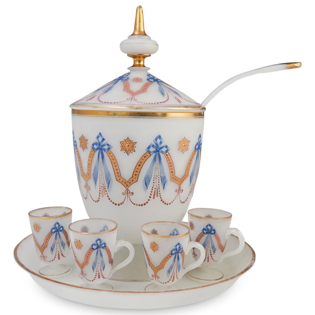 French Opaline Glass Punch Bowl: DESCRIPTION: A French frosted opaline glass punch set. Features a center cylindrical lidded punch bowl with hand painted ornate decorations in blue and gilt toned details. Finished with (4) matching g