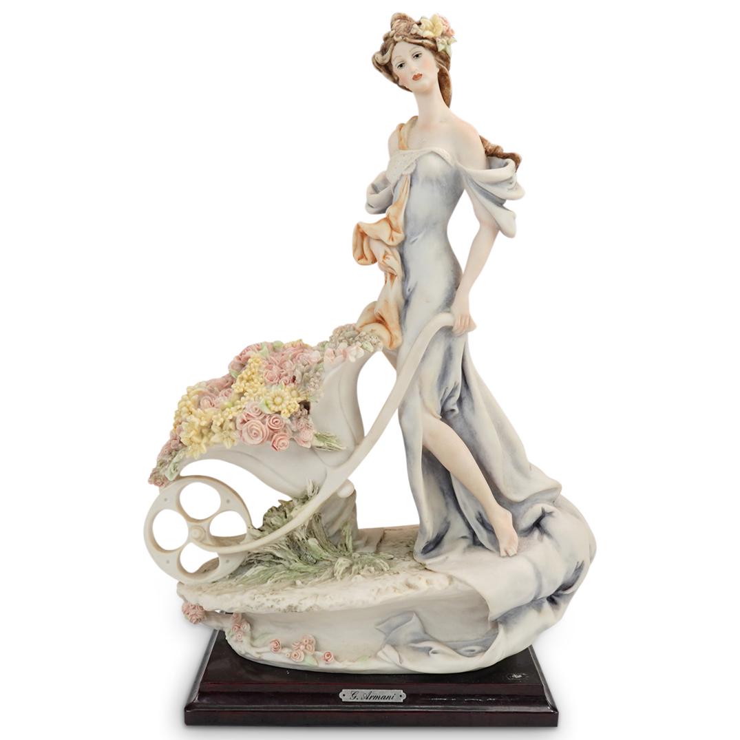 G. Armani "Lady with Flower Cart" Porcelain Figurine: DESCRIPTION: A Giuseppe Armani Capodimonte bisque porcelain "Lady with Flower Cart" figurine. Features a sensuous delicate woman shrouded in flowing garments as she holds a flower cart overflowing wit