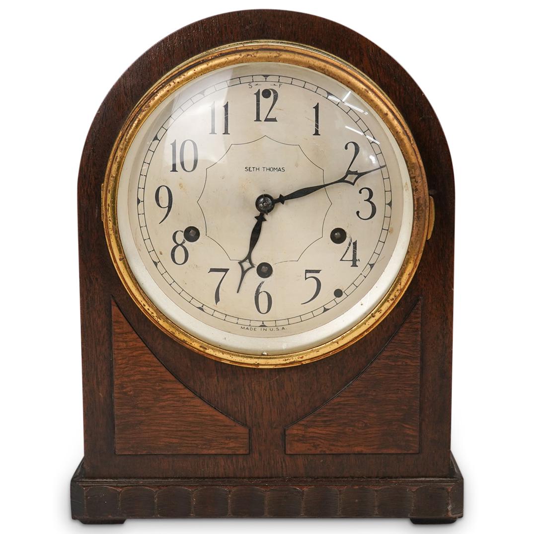 Seth Thomas Wooden Mantle Clock: DESCRIPTION: A Seth Thomas wooden mantle clock. Features a wood foundation with silver toned, black Arabic numbered dial and glass covered lens. Marked "Made In USA" Label underneath marked "No. 116 C
