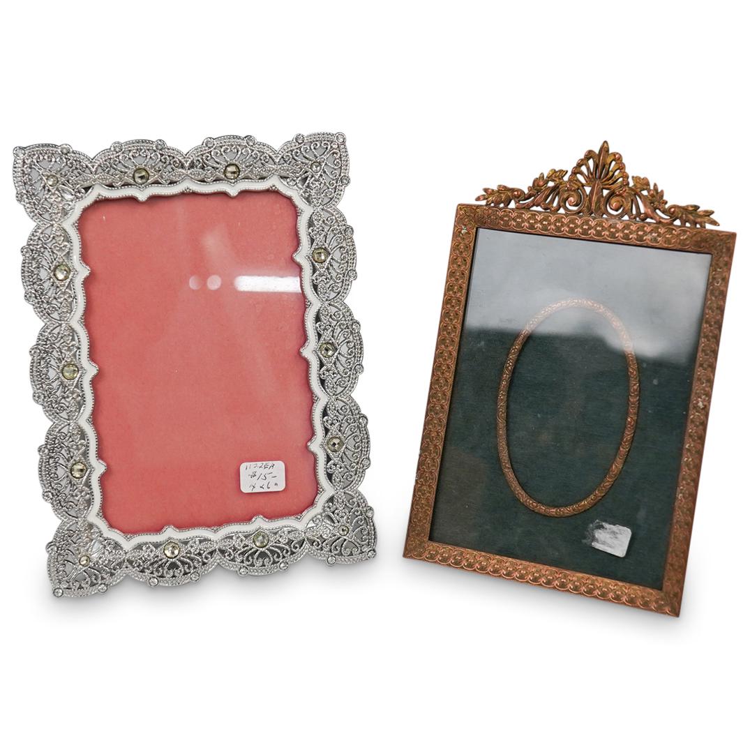 (2Pc) Ornate Photo Frames: DESCRIPTION: (2 Pc) A pair of ornate photo frames. Includes: (1) Ornate gilt bronze desk frame with open work wreath accents. (H: 7.5" x L: 5") (1) Silver toned metal with white ensemble design and in