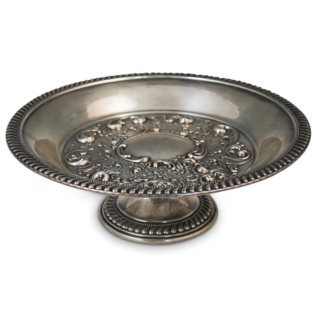 Arrowsmith Sterling Silver Tazza: DESCRIPTION: A sterling silver tazza by Arrowsmith features a repousse decorated interior with enveloping floral vine decorations, encompassed by a sequence patterned border. Stamped along the undersi
