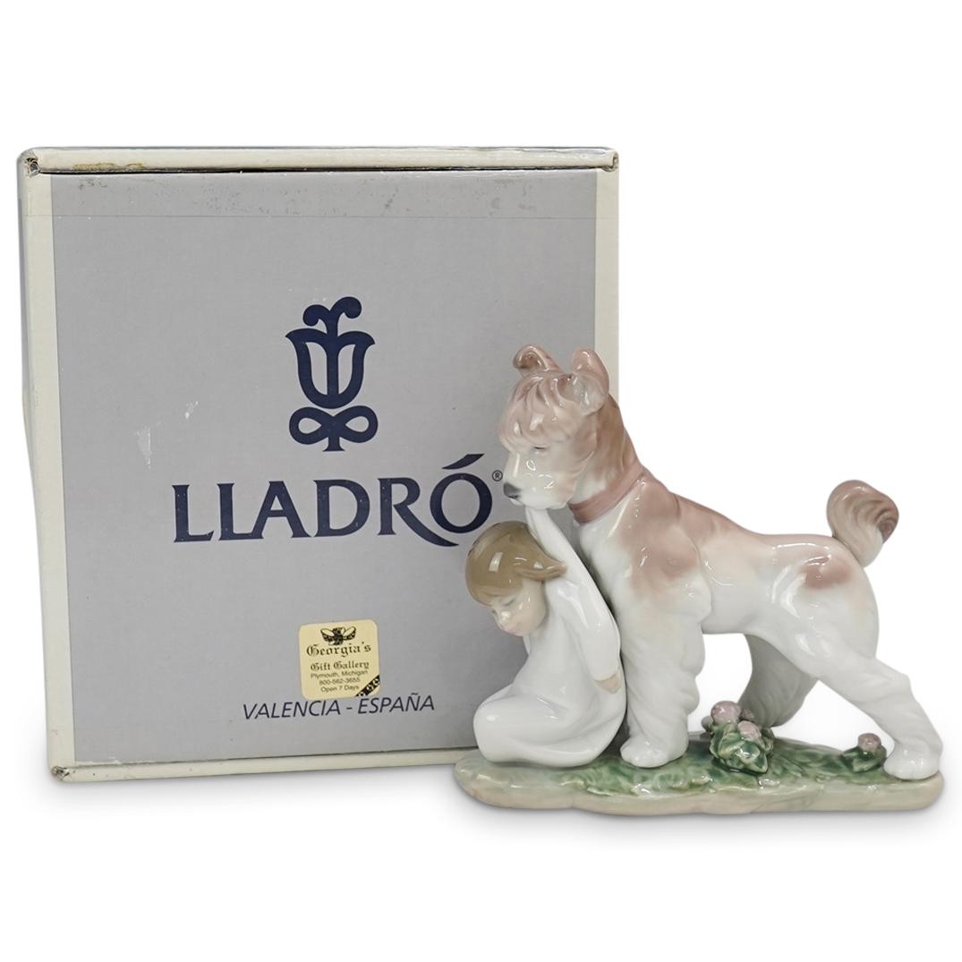 Lladro " Safe and Sound" Porcelain Figurine: DESCRIPTION: Lladro model 06556 "Safe and Sound " Porcelain Figurine depicting a dog carrying a boy by his shirt. The dog has a coloration of white and beige and the boy is wearing a white robe. Wonde