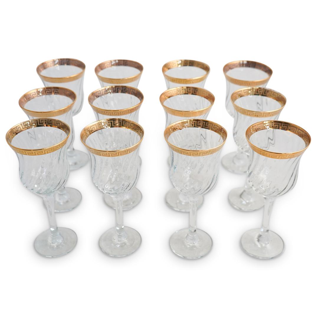 (12 Pcs) Versace Style Crystal Wine Glasses: DESCRIPTION: (12 pcs) A set of twelve tall footed crystal wine glasses with decorative geometrical gold gilt trim motif. This glassware set is designed with twisted pattern glass body and with gold gr