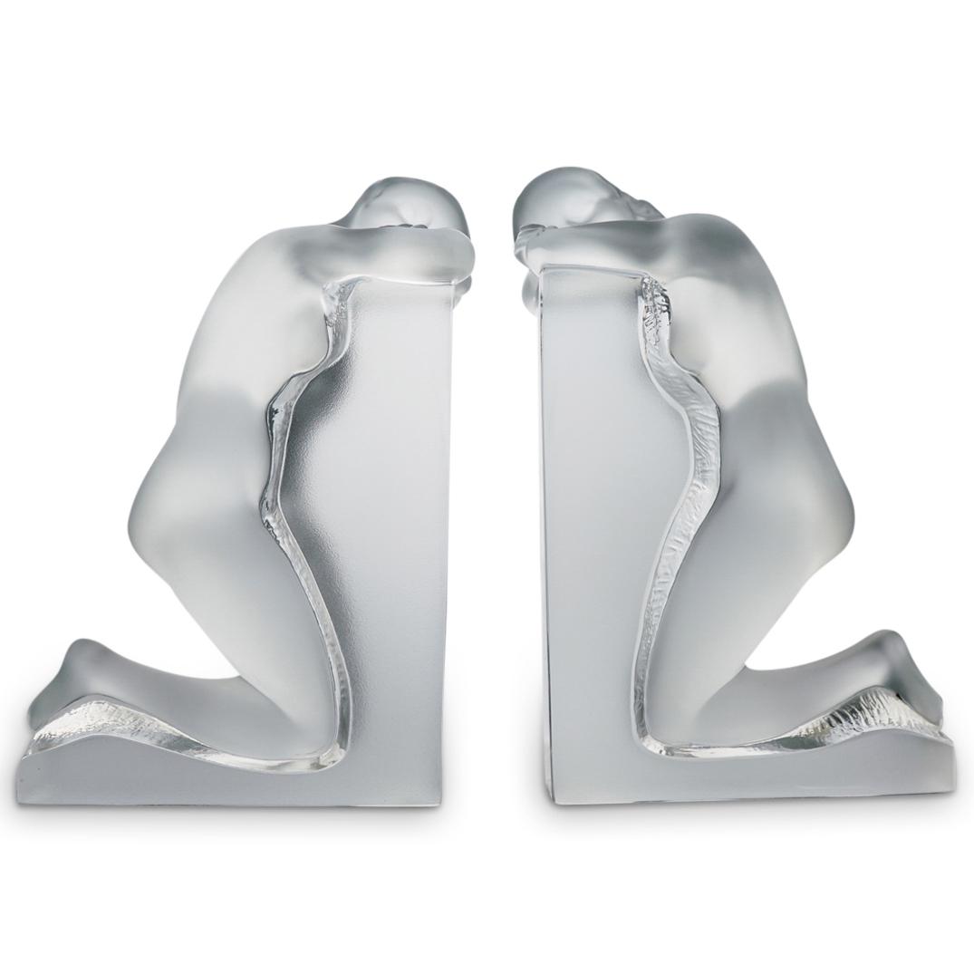 Lalique "Reverie" Crystal Bookends: DESCRIPTION: A pair of Lalique crystal "Reverie" bookends. Features posed frosted crystal nude women. Signed "Lalique R, France" CIRCA: 20th Cent. ORIGIN: France DIMENSIONS: H: 9" x W: 4" x L: 5.5" CO