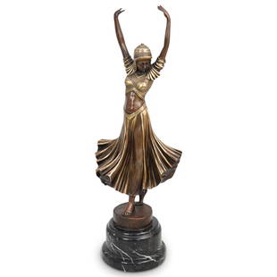 Demetre Chiparus Style Bronze Dancer: DESCRIPTION: A Demetre Chiparus style figural bronze dancer. Features the depiction of a dancer with an ornate flared dress, posed with arms raised upward. Further embellished with cold painted