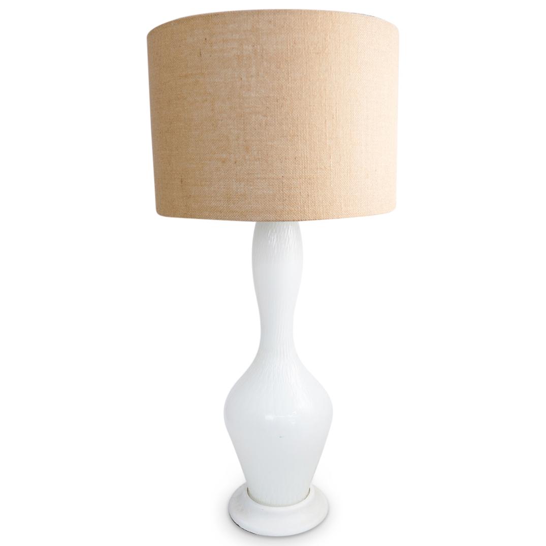 Vintage Murano Glass Lamp: DESCRIPTION: A Vintage Murano glass lamp features a bulbous bottom, with a long neck decorated in a frosted white lattice pattern. Completed with a beige burlap shade. CIRCA: 1950s ORIGIN: Italy DIMEN
