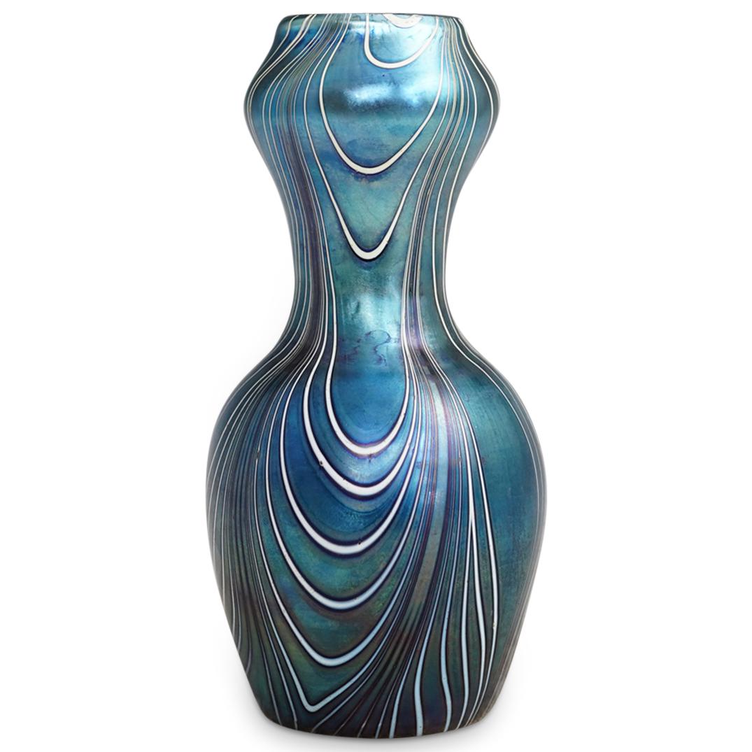 Johann Loetz Art Glass Vase: DESCRIPTION: A Johann Loetz art glass vase, in iridescent blue color with white and purple swirls decorations. CIRCA: 20th Century. ORIGIN: Germany. DIMENSIONS: H: 8" W: 4 1/4". Have a similar item to