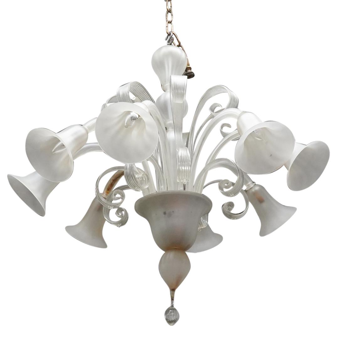 Frosted Murano Glass Chandelier: DESCRIPTION: A Murano blown glass chandelier with eight extending light socket fitted arms mounted with frosted glass shades. Further Designed with stacked clear blown glass scrolling arm accents and 