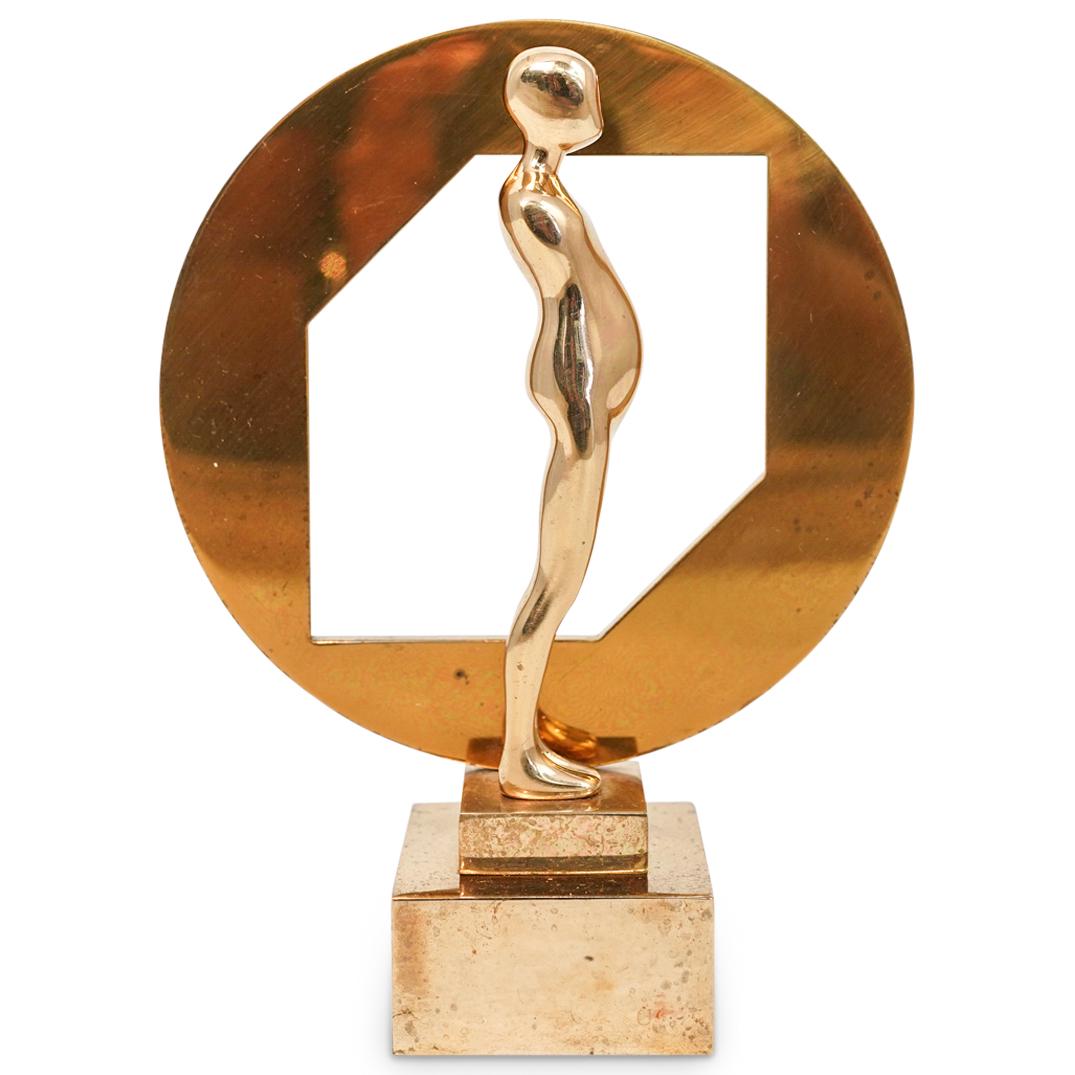 Ernest Trova (American.1927-2009) Cut Circle Figure: DESCRIPTION: A sculpture by American surrealist Ernest Trova titled Figure with cut circle, composed of polished bronze in gilded tones. Engraved with Trova mark and numbered "7/99" with date 1986. (C