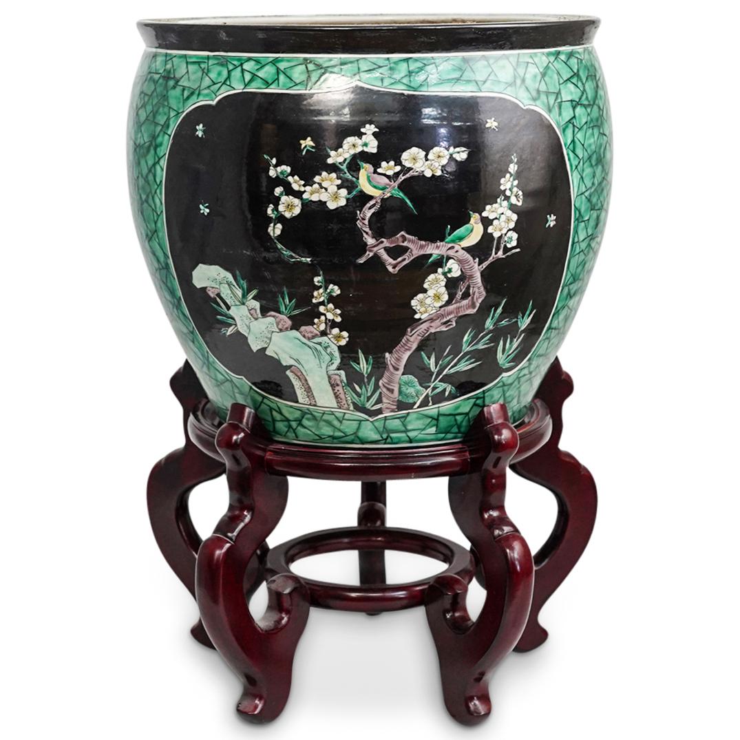 Chinese Porcelain Fish Bowl: DESCRIPTION: A Chinese porcelain fishbowl with crackle green design and cherry blossom motifs. Interior features seagrass and goldfish motifs. Complete on top of a wood display base. CIRCA: 20th Centu