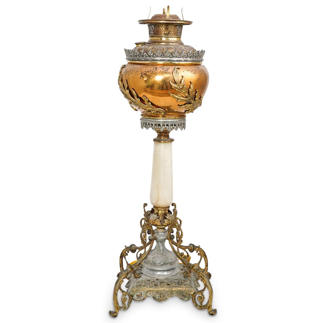 Antique Victorian Banquet Lamp: DESCRIPTION: An antique Victorian banquet lamp, featuring brass ormolu alloy ornate body, further embellished with a white onyx decorative piece. CIRCA: Late 19th Century. DIMENSIONS: H: 23 1/2". W: 8