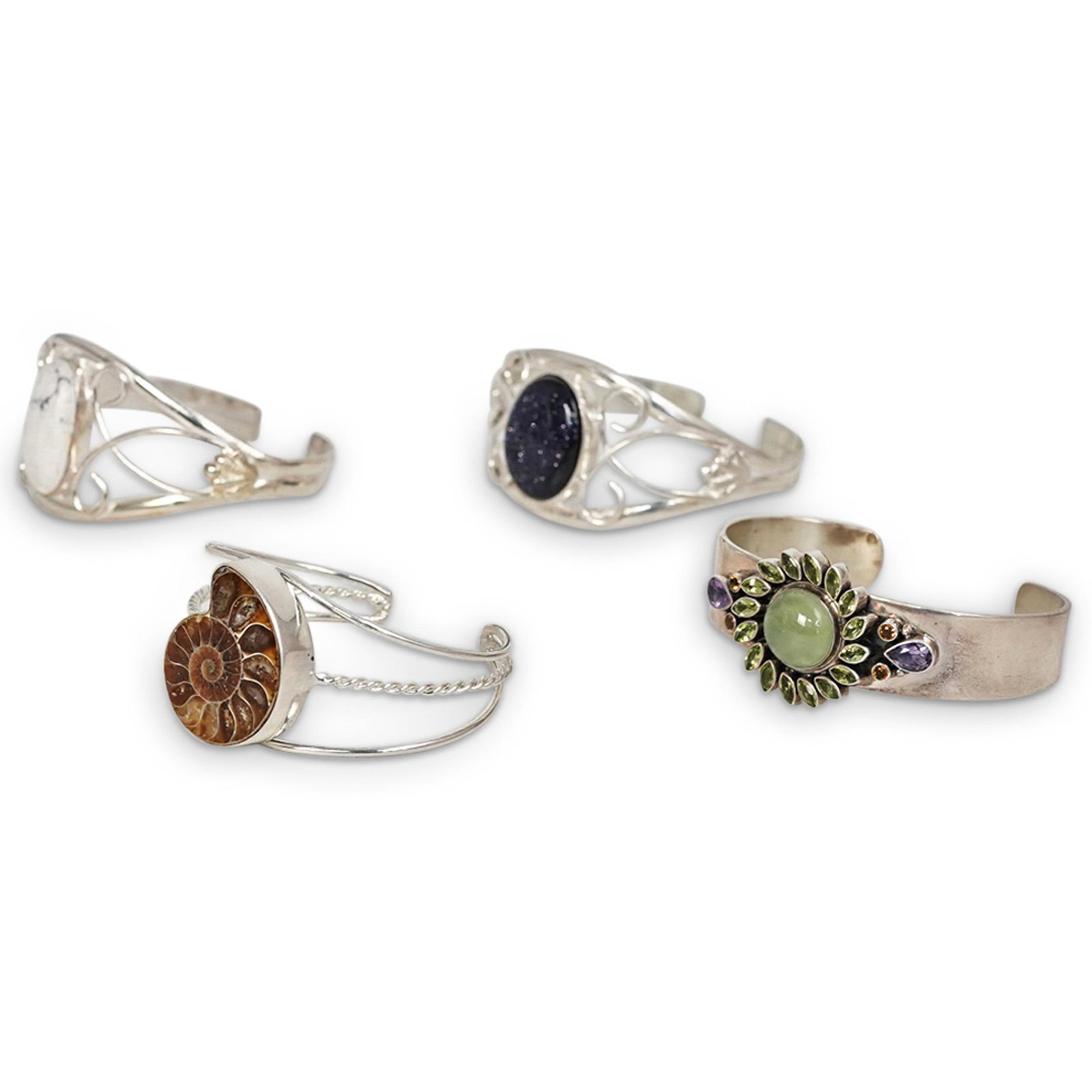 (4 Pc) Sterling Silver and Semi Precious Cuffs: DESCRIPTION: A group of sterling silver cuffs inserted with a series of stones, marked along the inner band "925". Total Weight: 135 Grams CIRCA: 20th Century. ORIGIN: Continental DIMENSIONS: Diameter