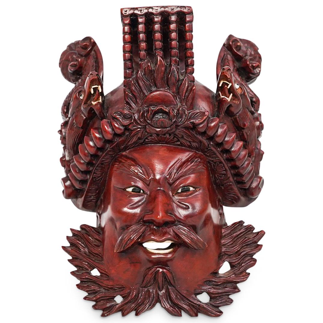 Balinese Hand Carved Mask: DESCRIPTION: A Balinese carved wood mask depicts a male figure with an intricately carved headdress, completed with polychrome teeth and glass eyes. CIRCA: 20th Century. ORIGIN: Bali DIMENSIONS: H: 8.