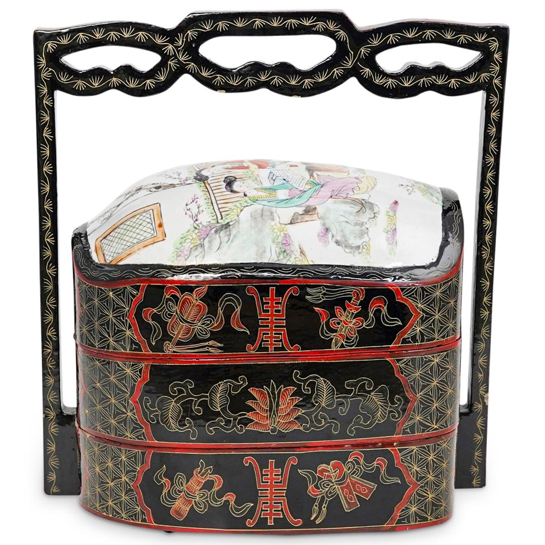 Chinese Porcelain and Lacquered Wedding Basket: DESCRIPTION: A Chinese wedding basket composed of a three level lacquered foundation, etched with floral patterns and symbols. Completed along the top with a hand painted porcelain lid depicting maide