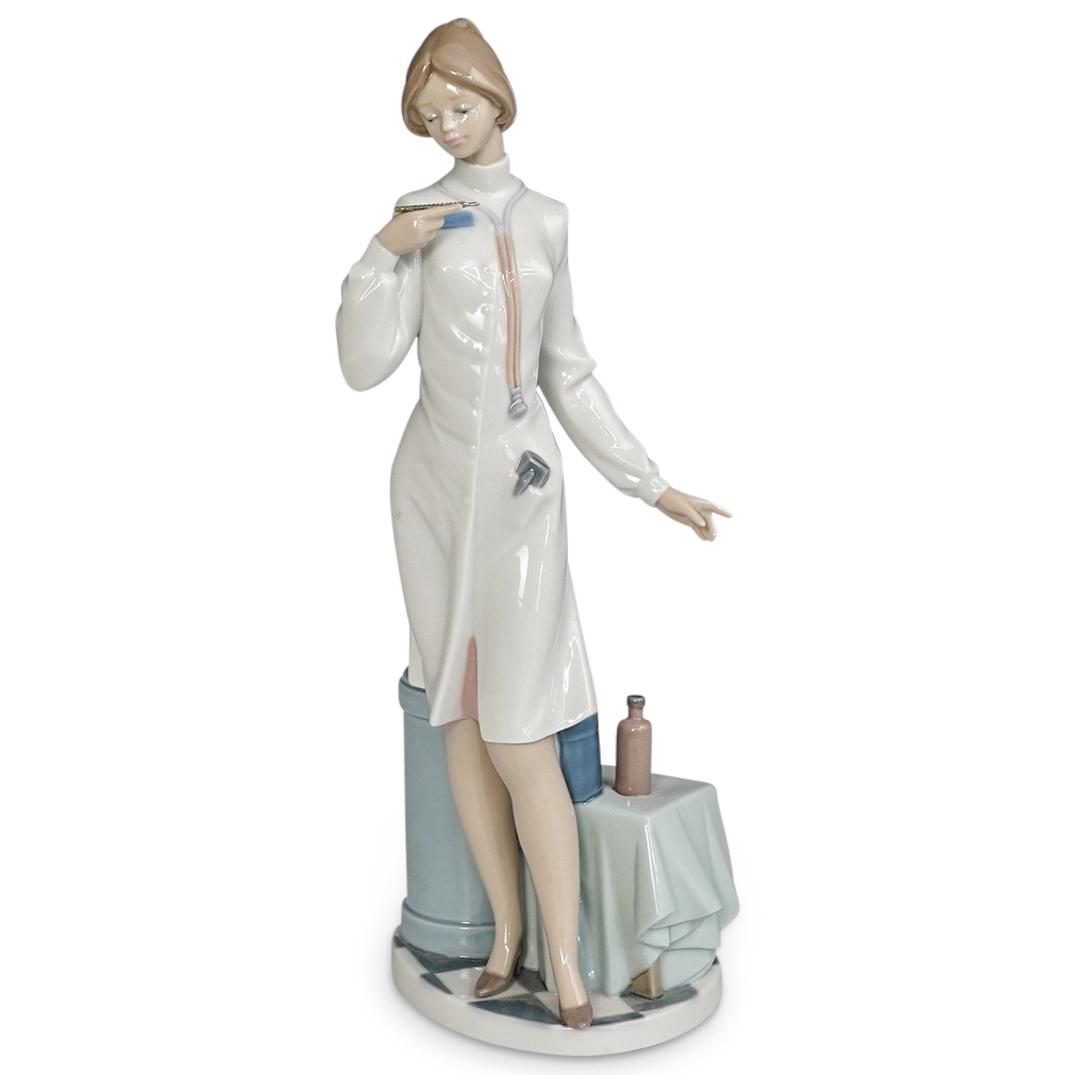 Lladro "Physician" Porcelain Figurine: DESCRIPTION: A Lladro "Physician" porcelain figurine featuring a female reading a thermometer. Marked with traditional Lladro stamp. CIRCA: 20th Century. ORIGIN: Spain DIMENSIONS: H: 13.5" x W: 5.5" x