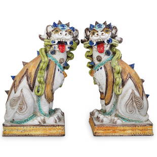 Pair Of Large Italian Majolica Foo Dogs: DESCRIPTION: A Pair of Italian Majolica foo dogs decorated with raised oriental accoutrement depicting ribbons, cuffs, and raised scrolling horns. Completed with multicolored accents and a gloss