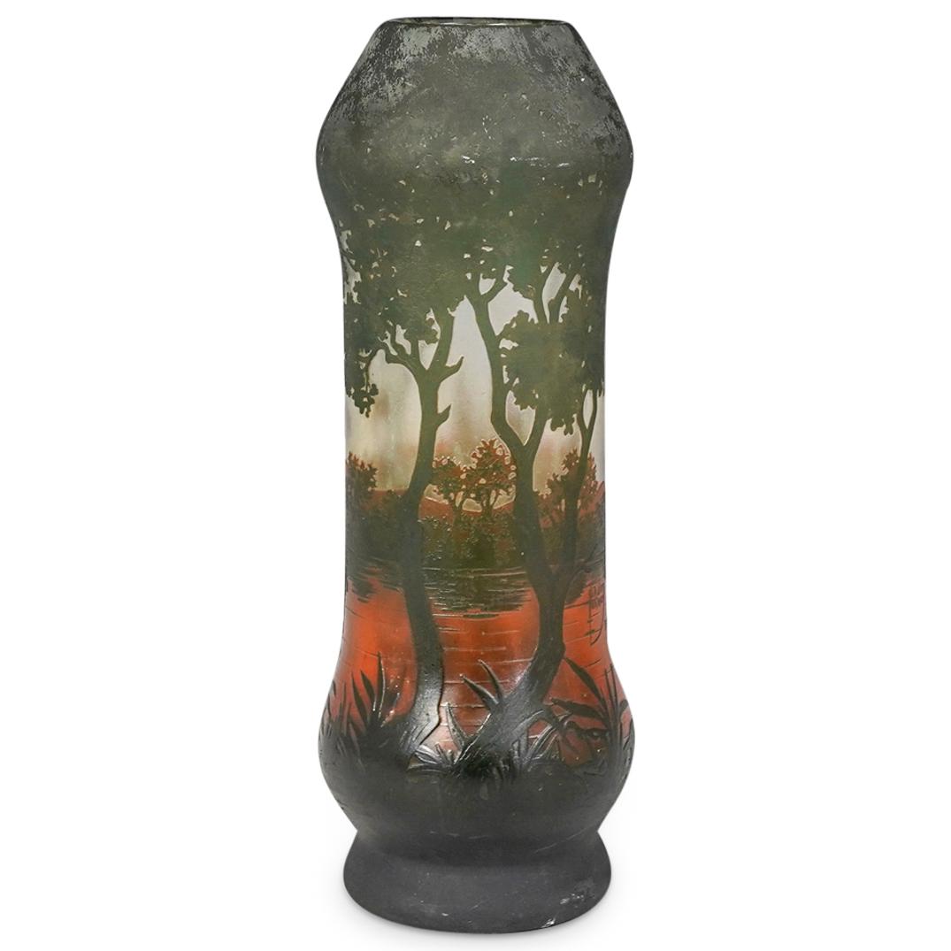 Daum Nancy Cameo Glass Vase: DESCRIPTION: Daum Nancy cameo glass vase with cylindrical tapered form. Features green vegetation and trees with an amber colored lake scene. Signed "Daum Nancy France" CIRCA: 20th Cent. ORIGIN: Franc