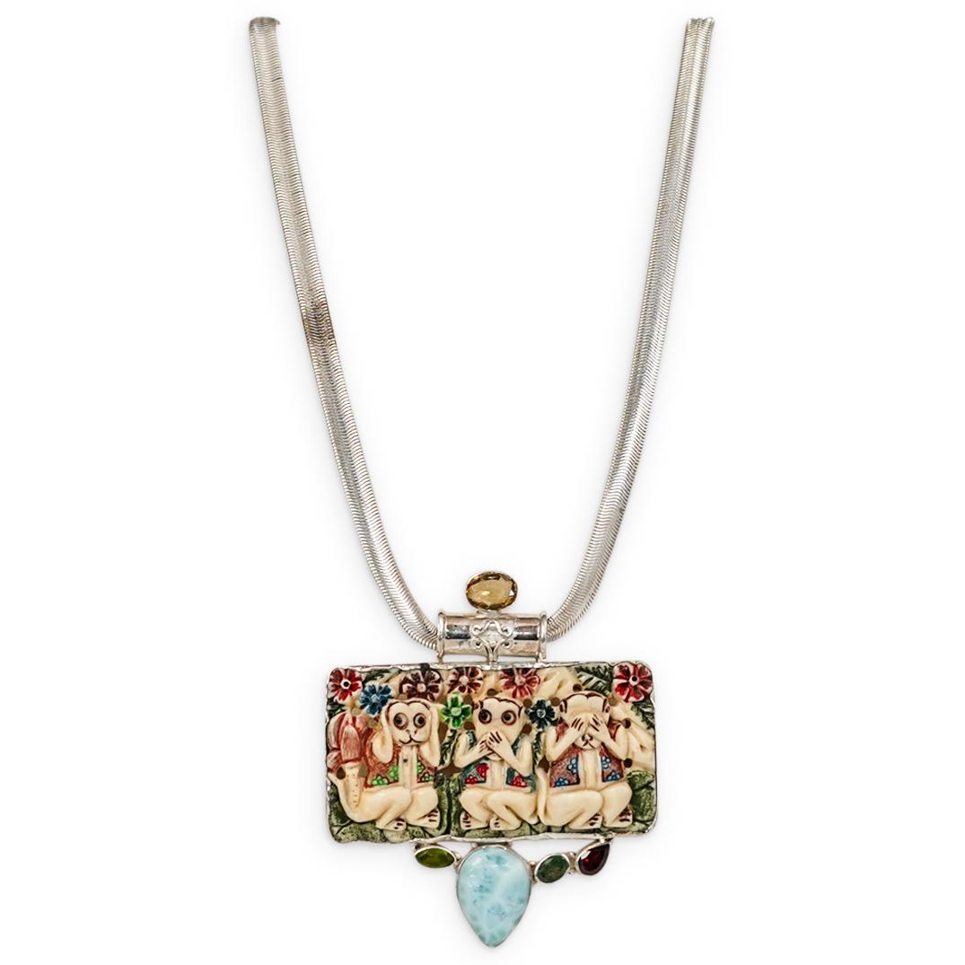 Sterling Silver Carved Bone and Semi Precious Stone: DESCRIPTION: A Sterling silver necklace featuring a snake chain design, fitted with a carved bone pendant depicting Three Monkey see no evil, hear no evil, speak no evil. Accented with Semi precious s