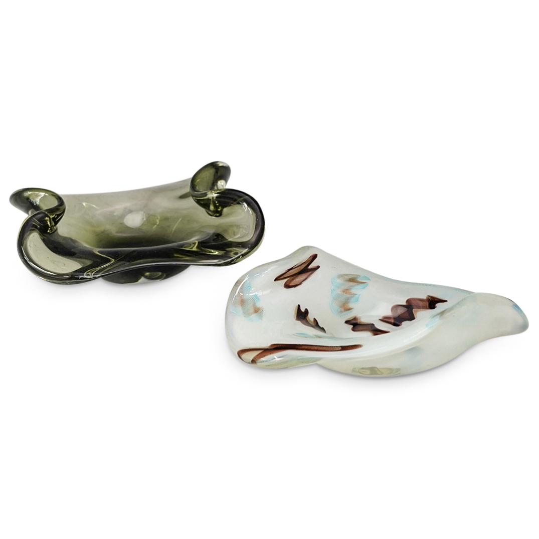 (2 Pc) Murano Art Glass Ashtrays: DESCRIPTION: (2 Pc) A Pair of Murano hand blown art glass ashtrays crafted in an organic form. This set includes one translucent green ashtray and one celeste blue ashtray with brown accents. CIRCA: 2