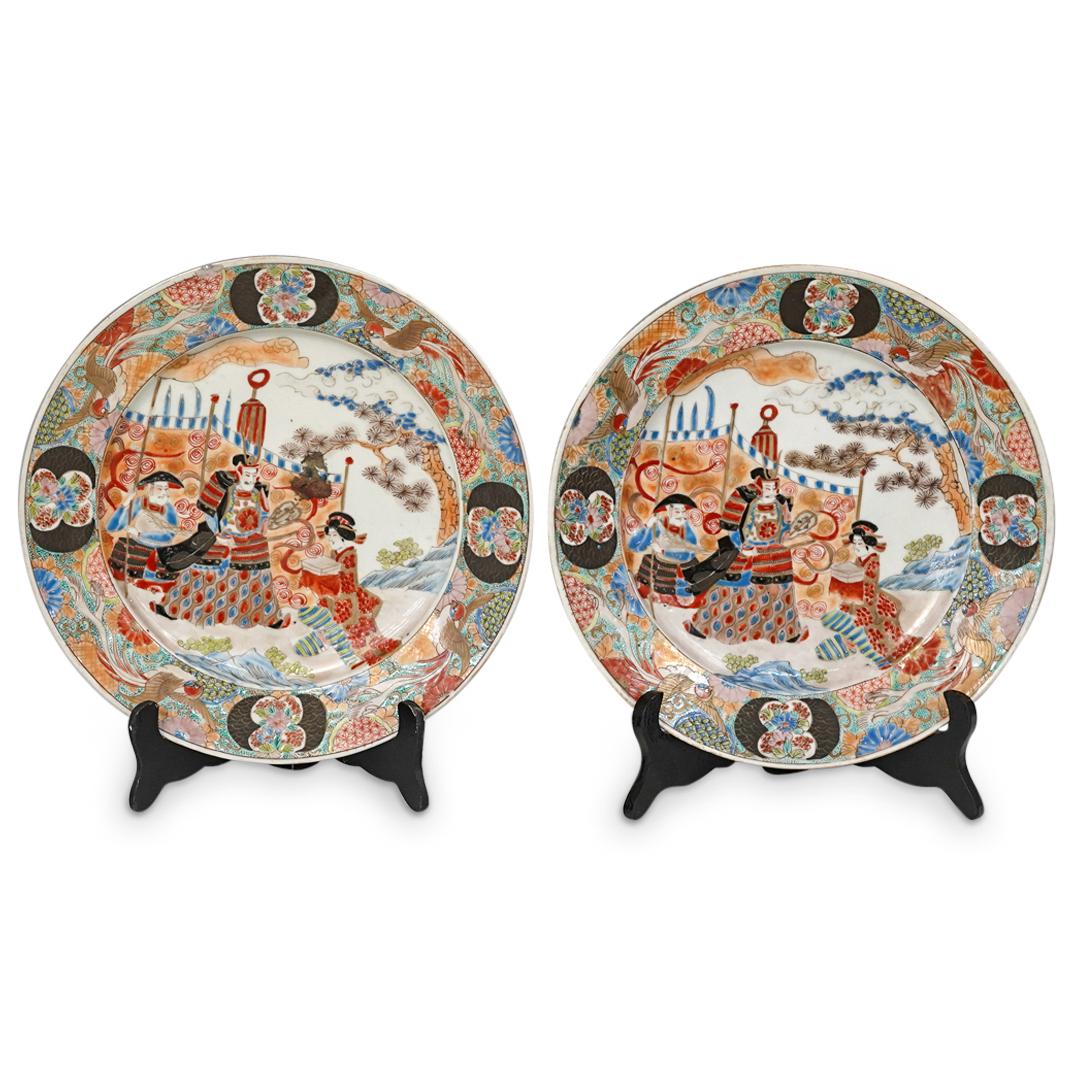 (2 Pc) Meiji Period Japanese Imari Arita Porcelain: DESCRIPTION: (2 Pc) A pair of Meiji Period Japanese Imari arita porcelain plates depicting a central palatial motif with emperor and geisha figures. It is further decorated with polychrome designs on 