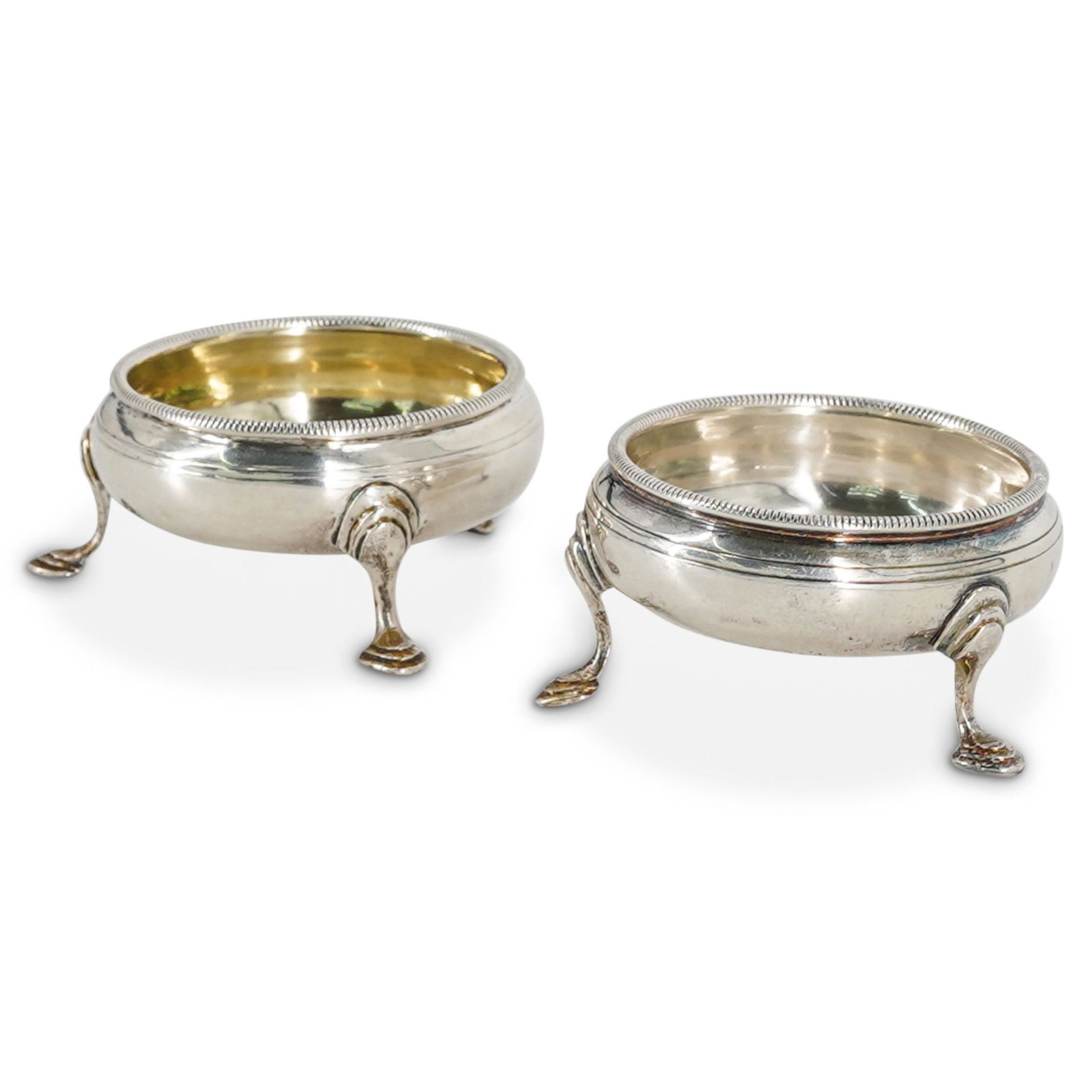 English Sterling Silver Salt Cellars: DESCRIPTION: Pair of English sterling silver salt cellars with tripod footed bases. Hallmarked: "CH, S," with pictorial marks. CIRCA: 19th Cent. ORIGIN: England DIMENSIONS: H: 1.5" x D: 3" (84 Grams)
