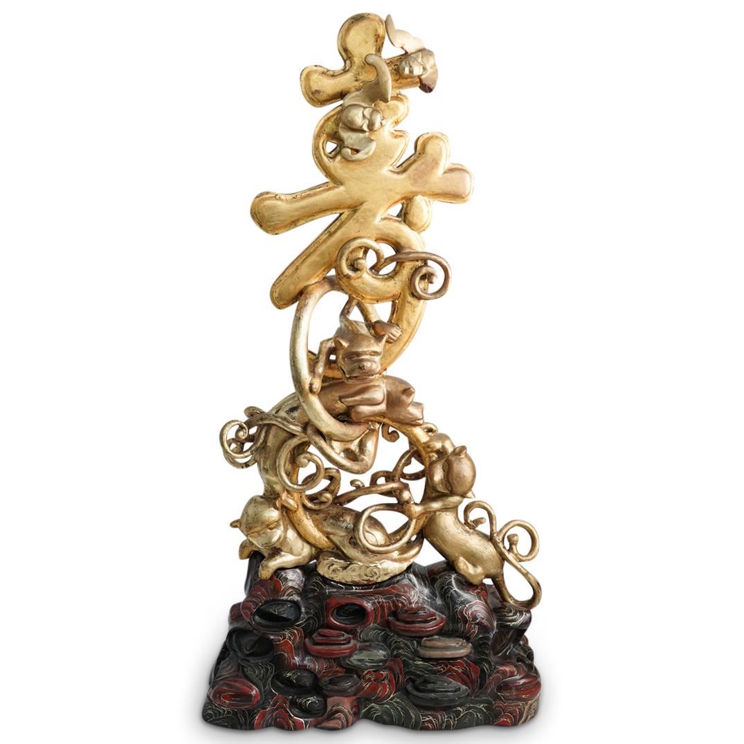 Chinese Gilt Wood Carved Character Symbol: DESCRIPTION: A Chinese gilt wood carved character plaque. Features an open work carved character symbol with climbing foo dog and flying bat motifs. Finished on a detailed rock formed base with glossy
