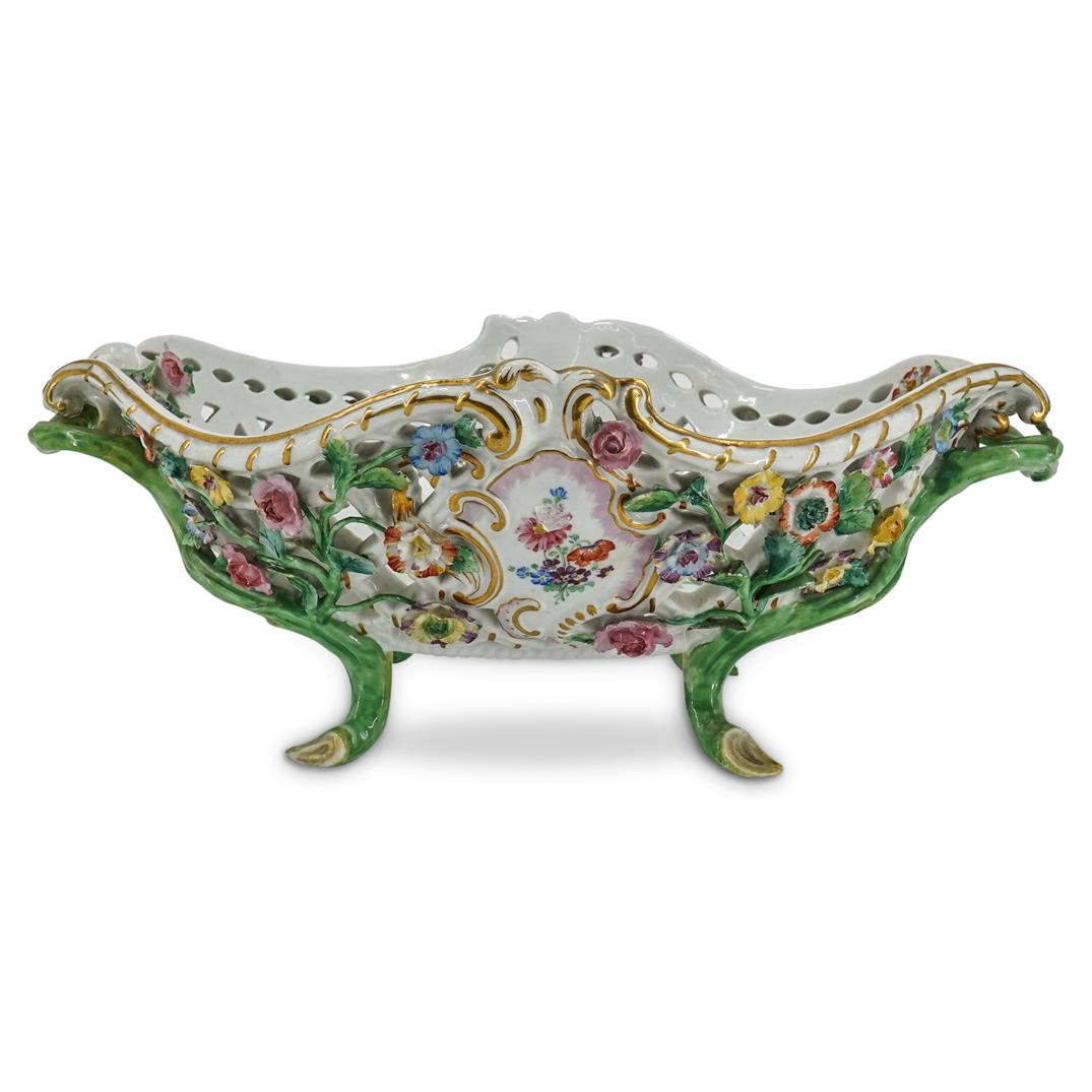 Meissen Porcelain Centerpiece Bowl: DESCRIPTION: Messin centerpiece bowl composed of porcelain with double branch formed handles, features a reticulated body with multi-colored floral details throughout. Marked with blue crossed swords.