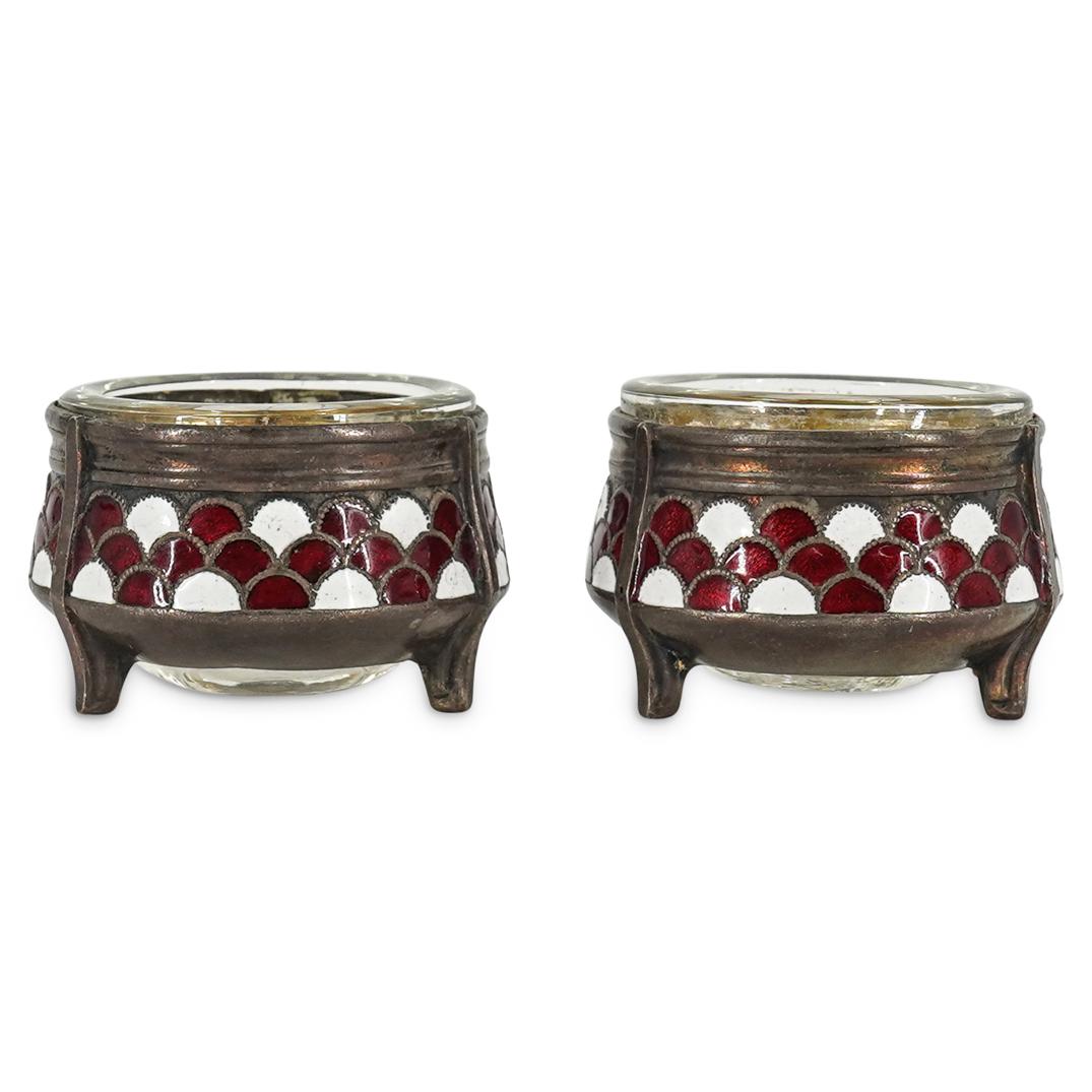(2 pc) Mstera Tri-Leg Enameled Silver Salt Cellars: DESCRIPTION: Pair of Mstera three-legged salt cellars each with a silver frame, enameled sides, and a glass inset. Sides are decorated with a red and white fan pattern. Each is marked on the underside