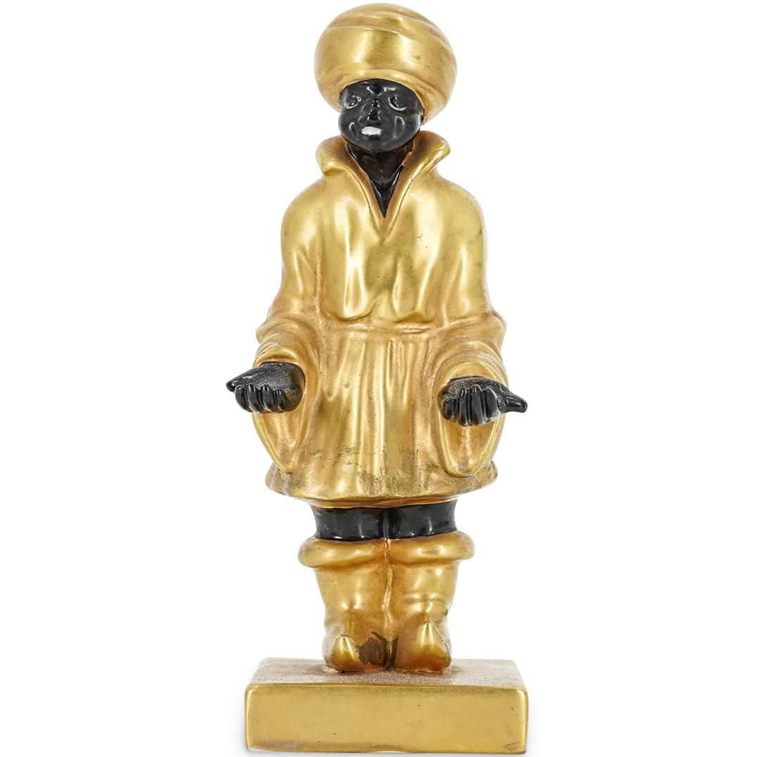 Porcelain Blackamoor For Bonwit Teller: DESCRIPTION: Porcelain figure of an African man in gilded turban, boots, and robe. Stamp on underside of piece says "For Bonwit Teller ITALY"; other mark appears to say "Eae" in elaborate script. Peel