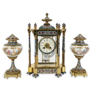 French Champleve Enamel Mantel Clock Set: DESCRIPTION: French champleve enamel mantel clock and garniture set, featuring a gilt metal foundation with enamel champleve corinthian column designs, inset scrolling floral motif accents, and top mo