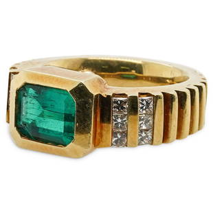 18k Gold, Emerald and Diamond Ring: DESCRIPTION: A Ring composed of an 18k yellow gold foundation, Bezel set with a 1.5ct Emerald, further accented along the shoulders with an approx. total of 0.32ct Square cut Diamonds. Total Weight: