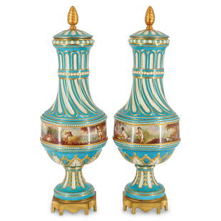 Pair of Antique Sevres Porcelain Urns: DESCRIPTION: An antique pair of Sevres porcelain lidded urns. Features an overall turquoise ground porcelain body with twist formed neck, raised floral motifs, and beaded details. Decorated with