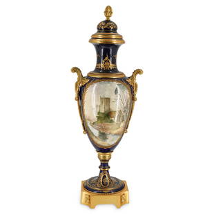 19th Cent. Cobalt Blue Sevres Urn: DESCRIPTION: 19th Cent. Sevres urn with cobalt blue porcelain body mounted to an ornate tapered gilt bronze supporting base. Designed with double gilt bronze hanging wreath handles and mounted trims.