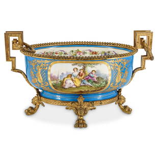 Sevres Bronze Mounted Porcelain Centerpiece Bowl: DESCRIPTION: Sevres bronze mounted porcelain centerpiece bowl with meandering pattern handles, blue ground body, with floral bouquet and courting scenes. Finished on four ornate beast footed legs. Und