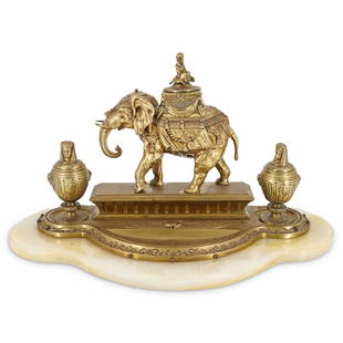 Egyptian Revival Gilt Bronze Inkwell: DESCRIPTION: An Egyptian Revival figural gilt bronze inkwell on onyx base.The bronze inkwell, with an elephant figure surmounted by seated figural finial, flanked by two inkwells with two