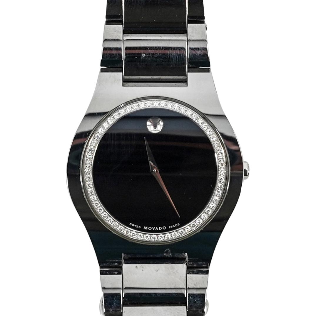 Movado Diamond and Stainless Steel Watch: DESCRIPTION: A Movado Stainless steel watch, with black-toned dial and diamond set bezel approx .20 cts total, quartz movement, and stainless band. Marked along the back #8096103. (Comes with Box pape