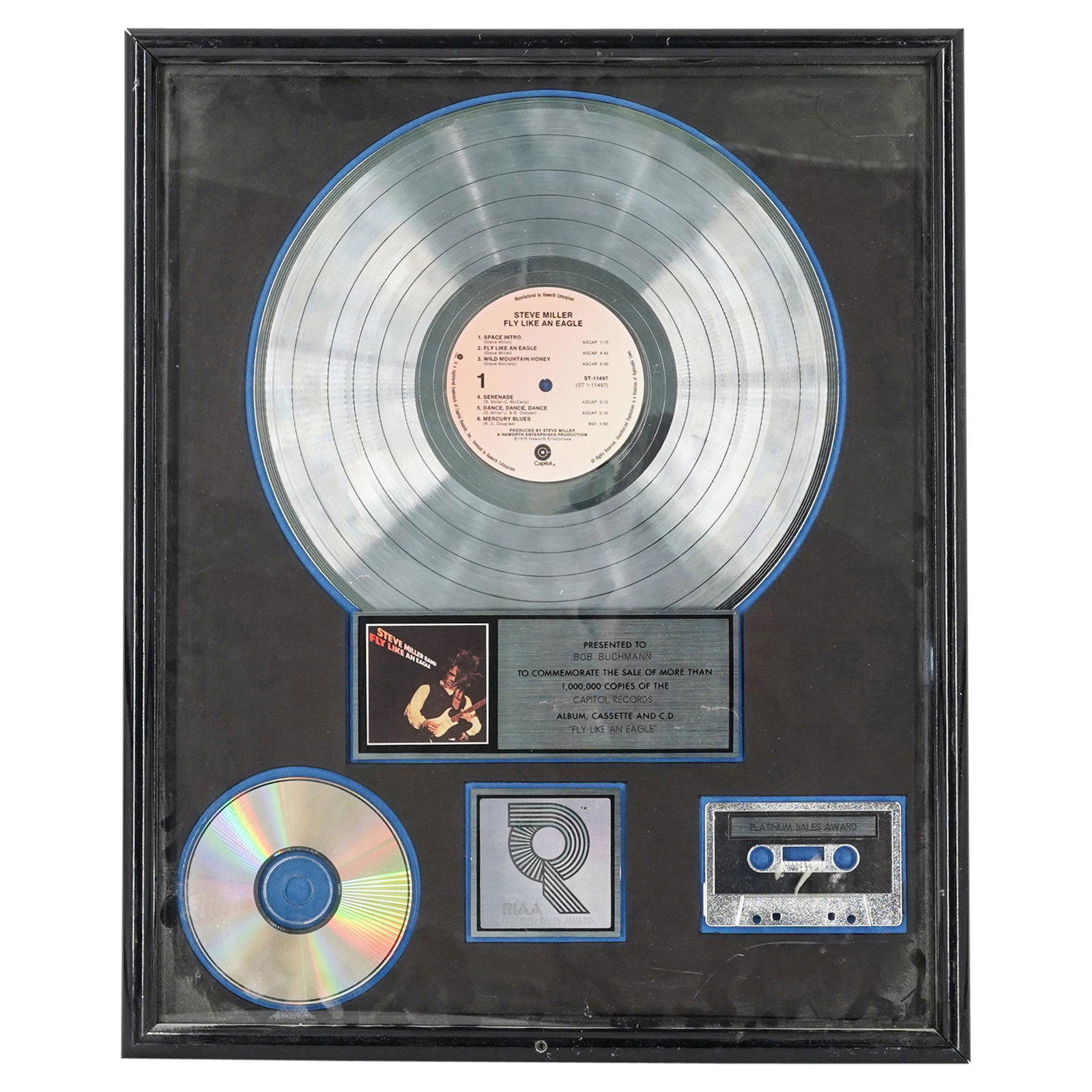 RIAA Steve Miller Band Sales Record Award: DESCRIPTION: Steve Miller "Fly Like An Eagle" RIAA sales record award, presented to Bob Buchman to commemorate the sales of more than 1,000,000 copies. Capitol Records, album cassette and CD. Mounted 