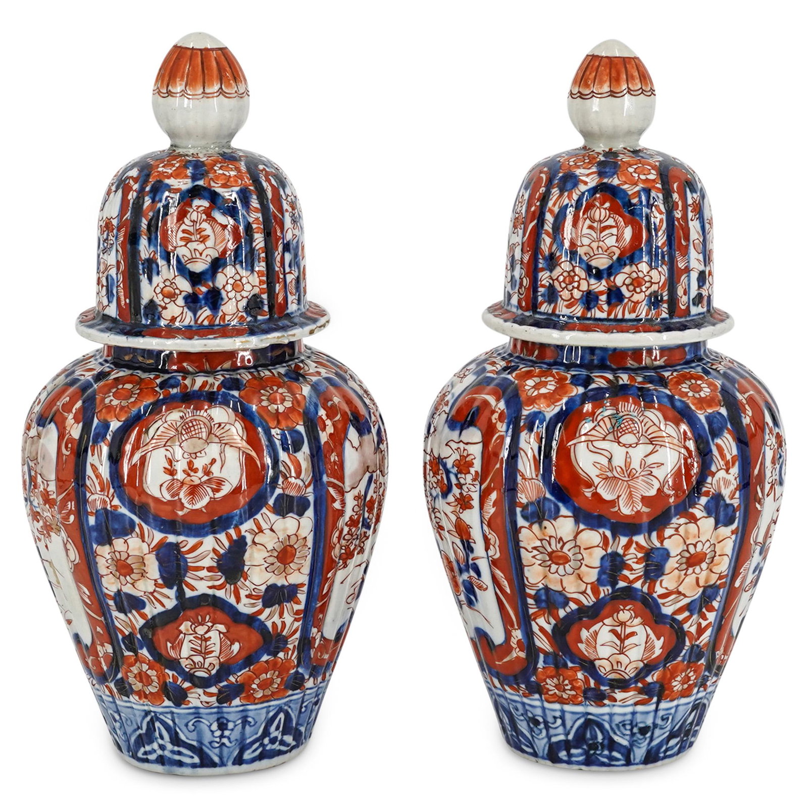 Pair of Antique Imari Porcelain Urns: DESCRIPTION: A pair of antique Chinese porcelain lidded urns with ribbed exteriors. Features multicolored floral Imari designs with acorn finials. CIRCA: 19th Cent. ORIGIN: China DIMENSIONS: H: 11.25"
